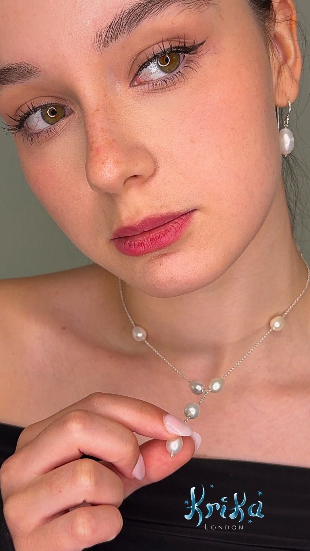 Close-up of a woman wearing a pearl necklace with a blurred background

